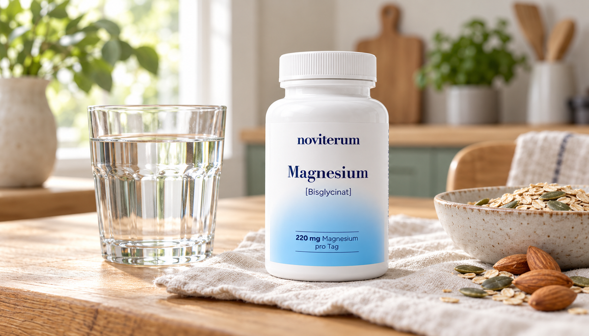 Noviterum Magnesium neben einem Glas Wasser, Haferflocken, Kürbiskernen und Mandeln auf einem Küchentisch.